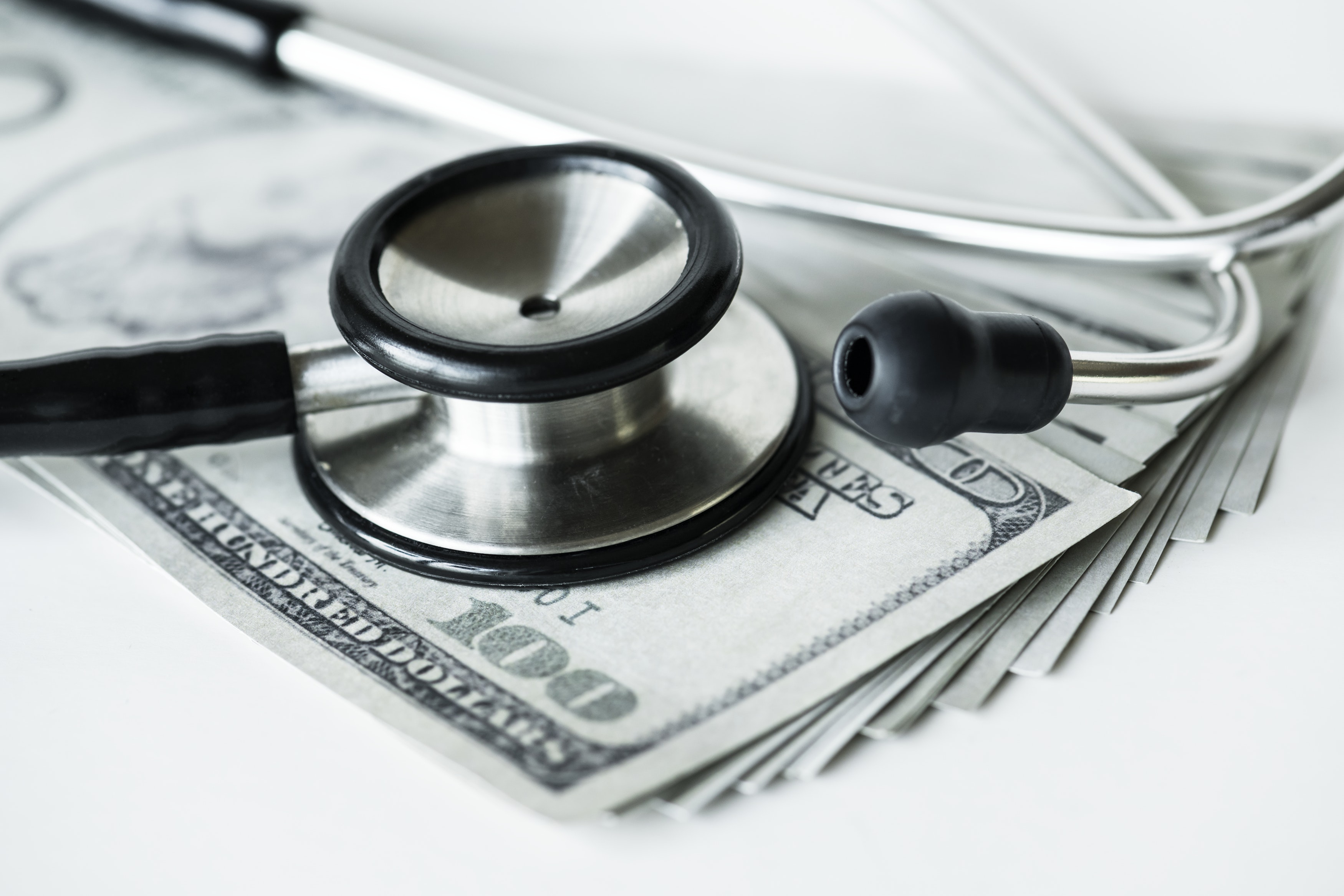 Stethoscope lying on top of pile of money